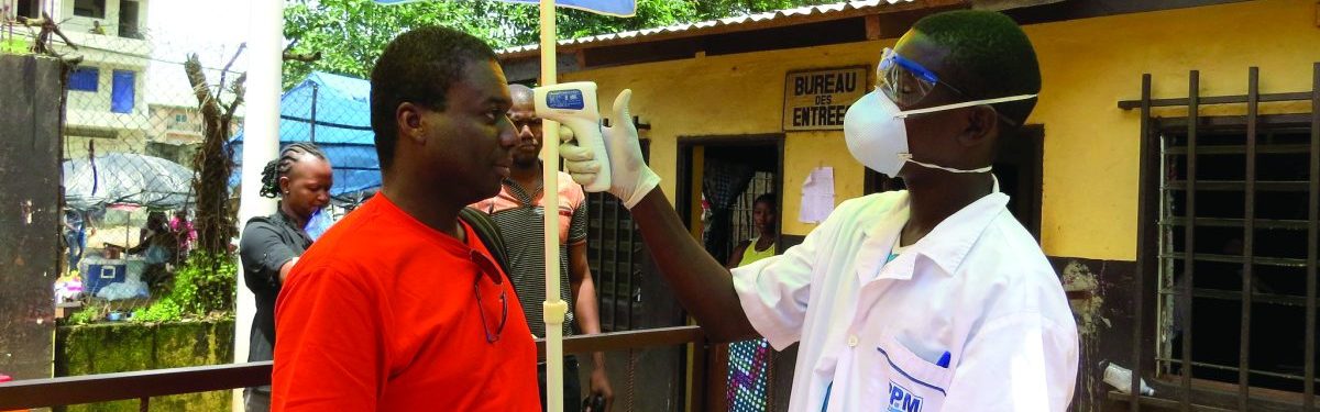 Man is screened for fever symptoms by a healthcare worker before entering a building during Ebola pandemic