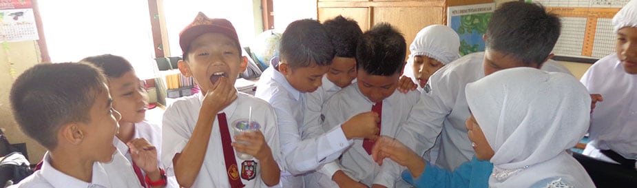 On October 15, 2014, during an Indonesia FETP campaign to improve coverage against filariasis (a parasitic infection caused by roundworms), elementary school students receive preventative medicine.
