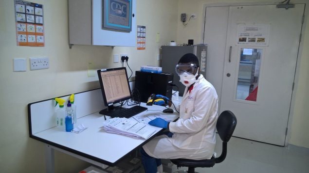 Laboratory staff sits at a laboratory bench.