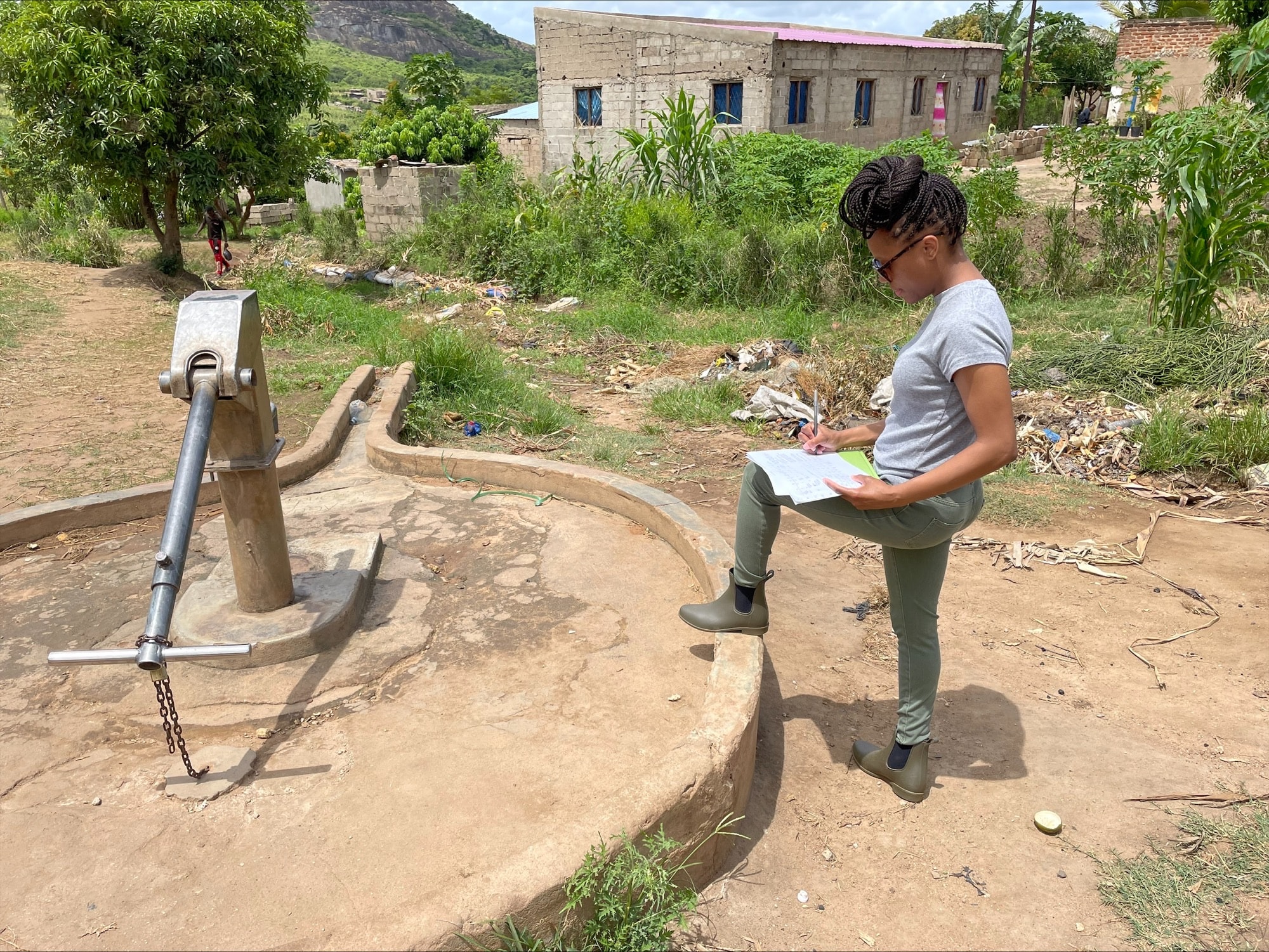Dr. Frederica Lamar completing a Sanitary Inspection Form for a hand pump well