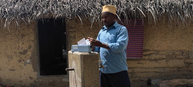ZAWA technician on Pemba conducting a monitoring visit at a community tap stand