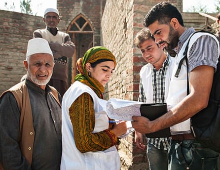 Team leader Tulseef with Waseem, randomly selecting households for interview from the village leaders list in a remote village in the Kashmir Valley in November 2015.