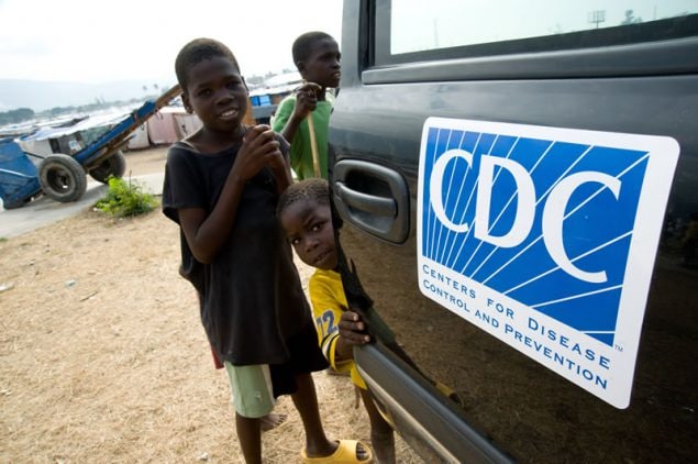 Boys cluster around a truck with the CDC logo on it.