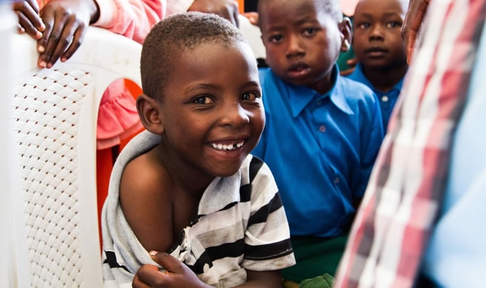 Young Samburu boy in Kenya smiles as he waits for his measles-rubella vaccine.