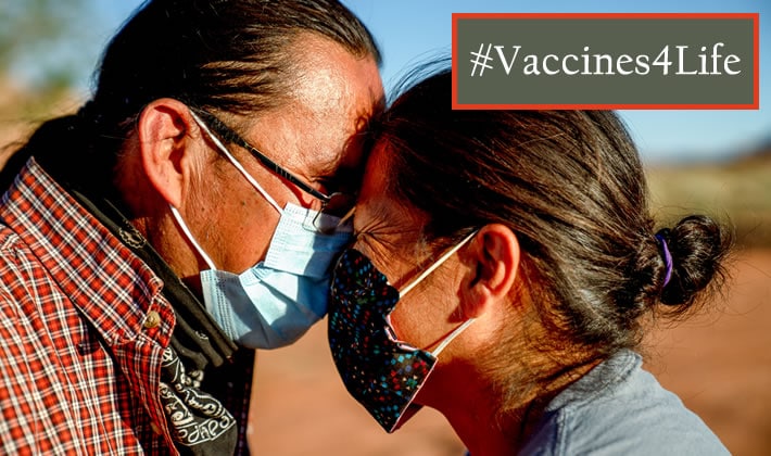 Two Ute Native Americans wearing face masks lean close to each other, smiling. #Vaccines4Life