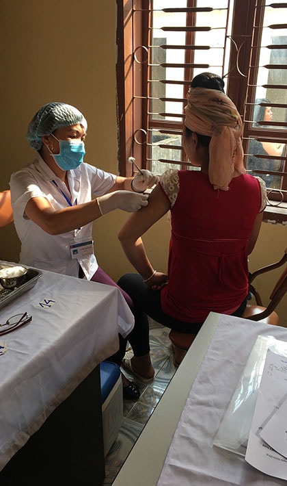 A healthcare worker vaccinates a woman at a clinic in Vietnam, 2018.
