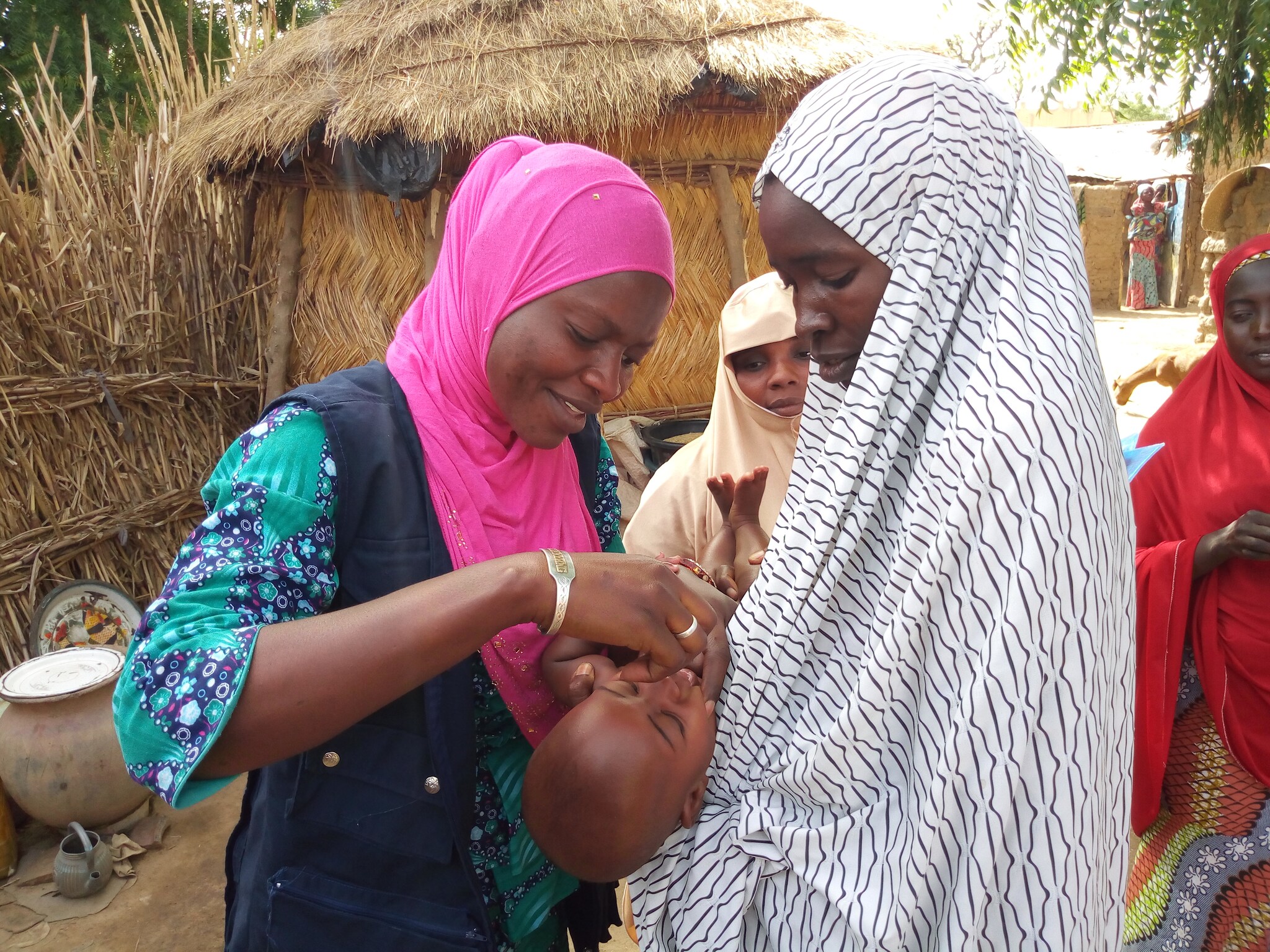 STOP participant in Nigeria vaccinating a child during a polio vaccination campaign