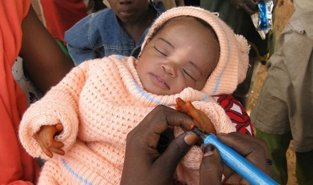 O dedo de um bebé está marcado com um marcador para mostrar que ela recebeu uma vacina contra a poliomielite.