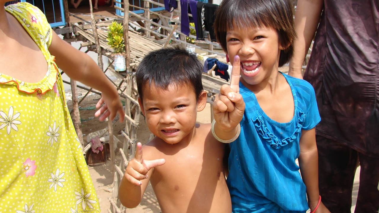 Children in Cambodia show their marked fingers, providing they've been vaccinated.