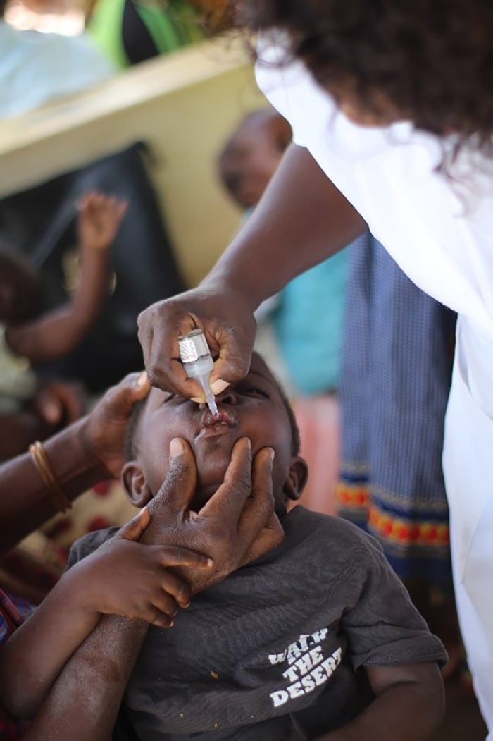Giving an oral polio vaccine to an infant in Mozambique.