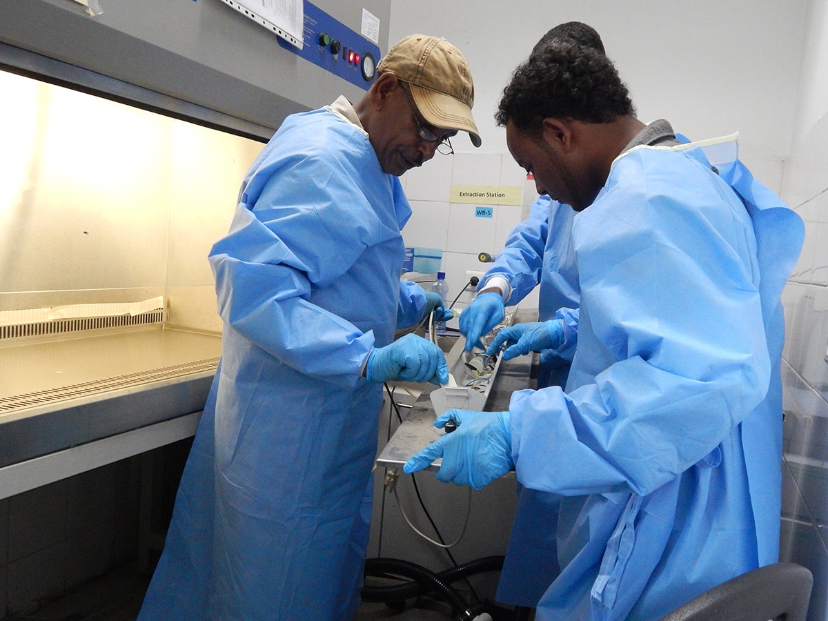 Engineers in an Ethiopia biosafety lab work on the equipment