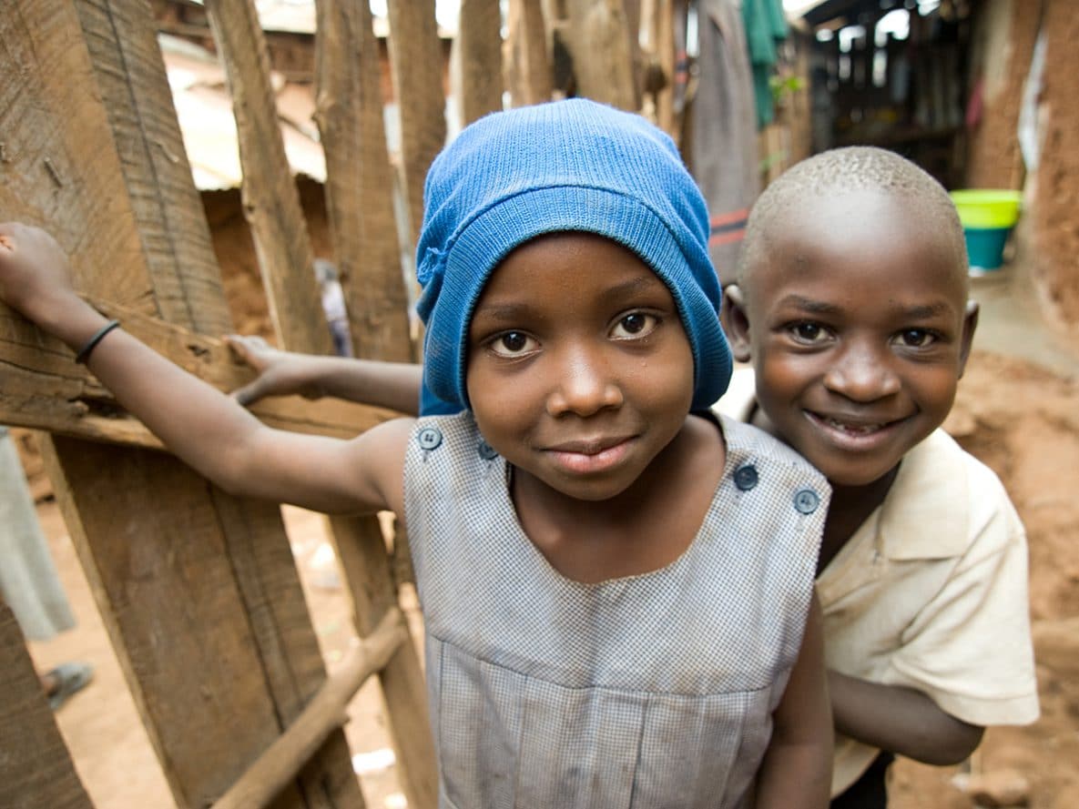 A young girl and boy outside of their family home in the Kibera informal settlement in Nairobi, Kenya.