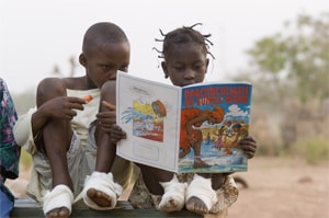 While at the containment center in Ghana two children look at a picture book about Guinea worm disease. Credit: The Carter Center/Louise Gubb, 2007