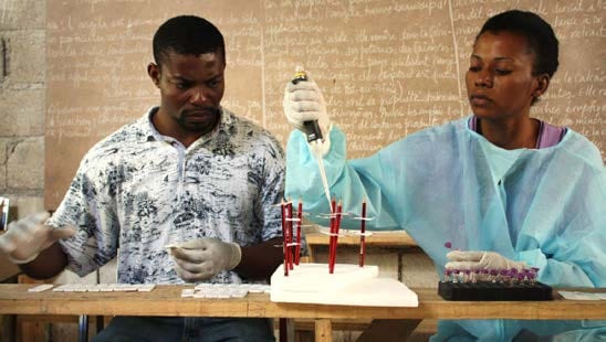 Two laboratory technicians with Haiti’s ministry of health are processing blood samples in order to test for malaria. Credit: Alaine Knipes.