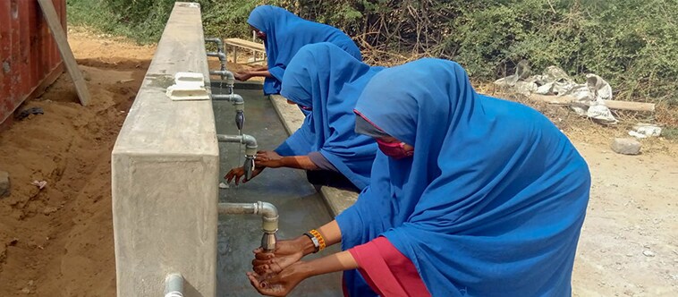 Three female students at the Juba Primary School in Dagahaley camp, inside Kenya’s Dadaab refugee camp, wash their hands.