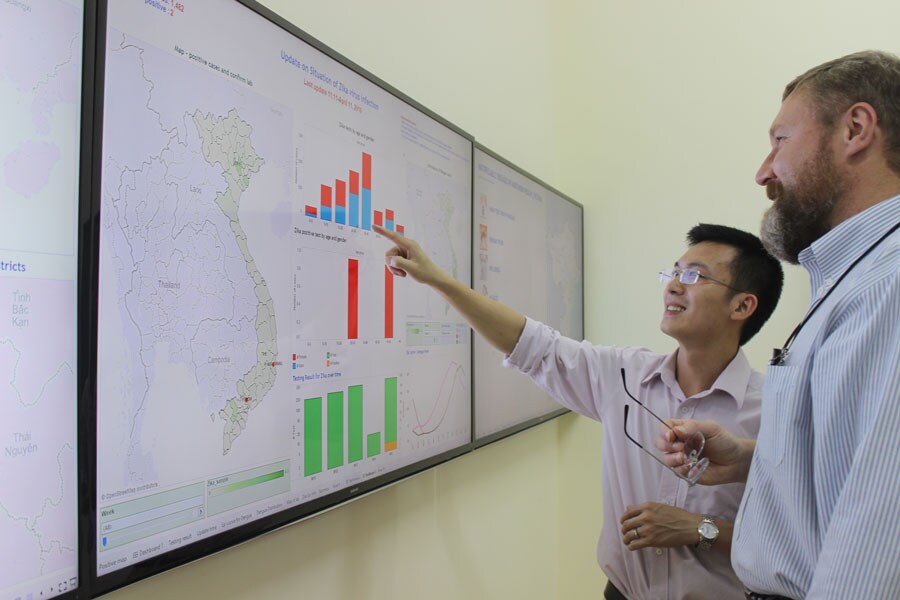 A photo of the data dashboard with Dr. Tran and Peter Rzeszotarski, CDC Emergency Management Specialist.
