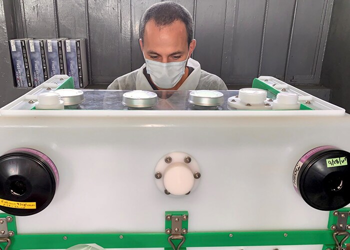 James Graziano, working in a hard-shell glove box inactivating suspect Ebola samples for RT-PCR testing.