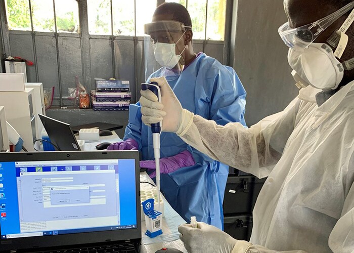 Fabrice Mambu (INRB) and Yibayiri Osee Sanogo (r) loading inactivated samples for RT-PCR testing.