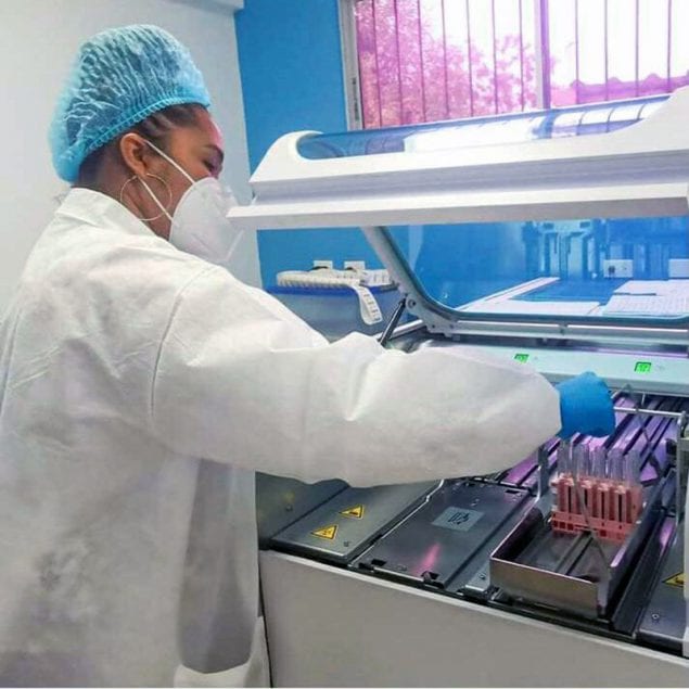 A lab technician processes COVID-19 tests