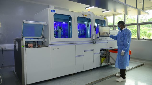 Lab technician operates an automated viral load testing machine at the CDC-supported National Health Laboratory and Diagnostic Services facility.