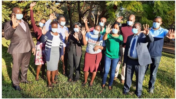 Staff from Zimbabwe’s Gweru Provincial Hospital hold up five fingers