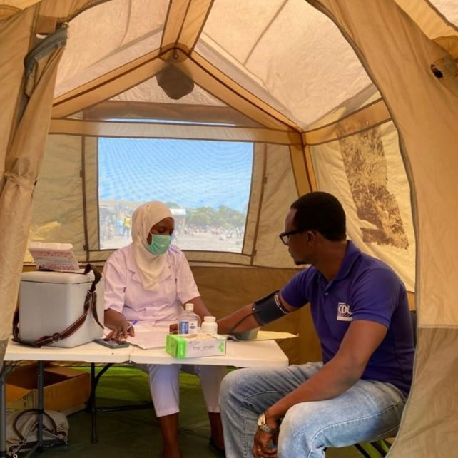 U.S. CDC’s Oscar Rwabiyago, MD,  observes a healthcare worker as she performs all the services offered at this mobile health clinic.