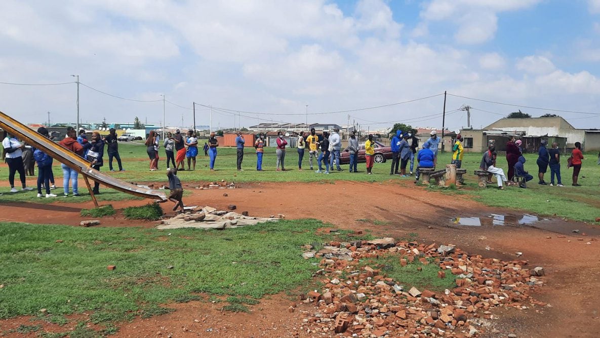 Photo of people lined up outside in Ekurhuleni, South Africa to receive COVID-19 vaccines at a mass vaccination site.