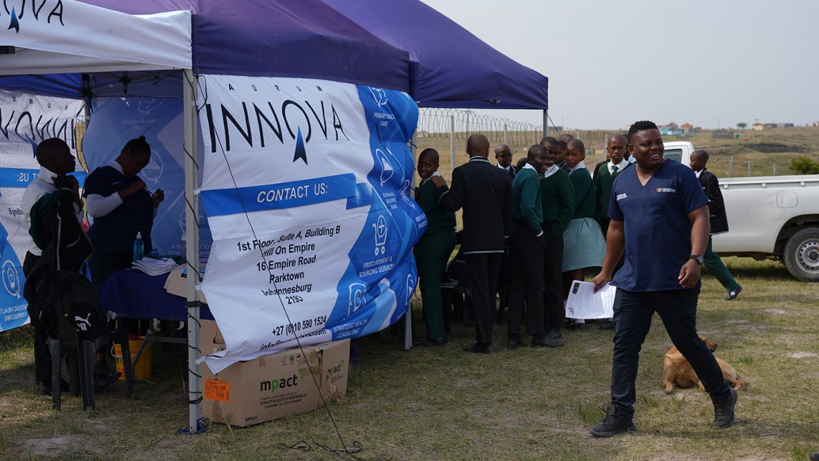 Photo of people inside a tent outside a school in Eastern Cape Province, South Africa where students received vaccines.