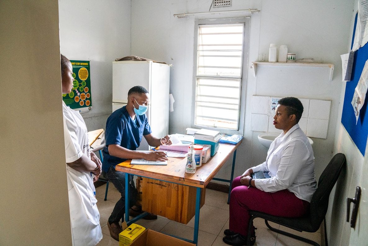 Photo of a patient receiving a COVID-19 vaccination consultation with a medical professional.