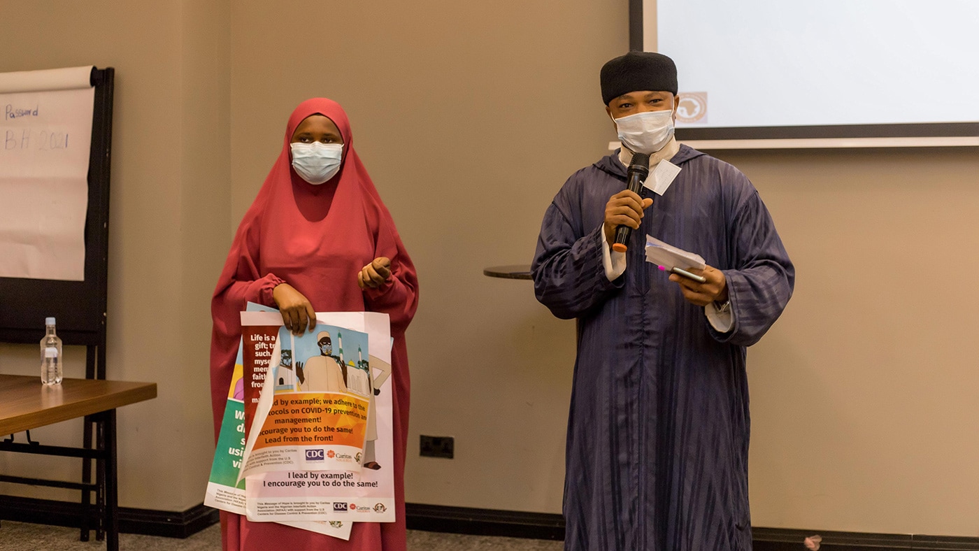 Photo of two religious leaders presenting information about COVID-19 prevention and treatment during the Messages of Hope workshop designed to inform communities.