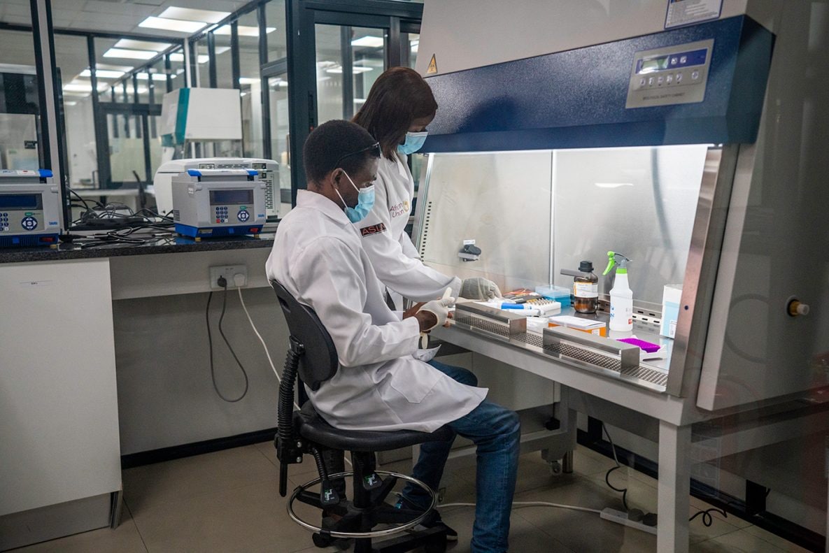 Photo of two workers testing COVID-19 samples inside Zambia National Public Health Institute (ZNPHI) laboratory.