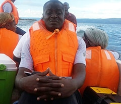 man wears a lifejacket riding with others on a boat