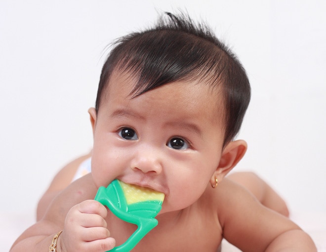 Baby chewing on toy