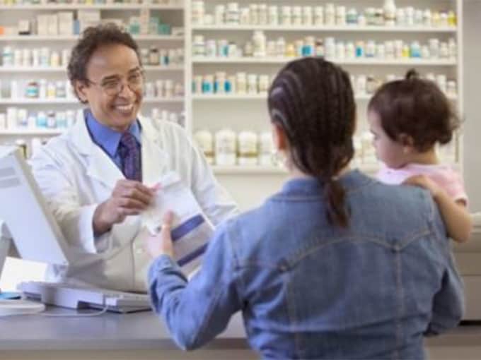 Pharmacist talking to mom and baby