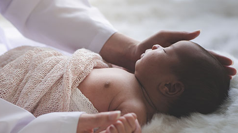 Mother touches sleeping infant