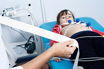 A doctor looks over results from a child’s electrocardiogram