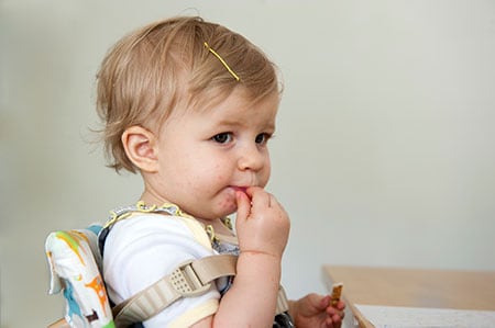 Toddler girl eating at a table