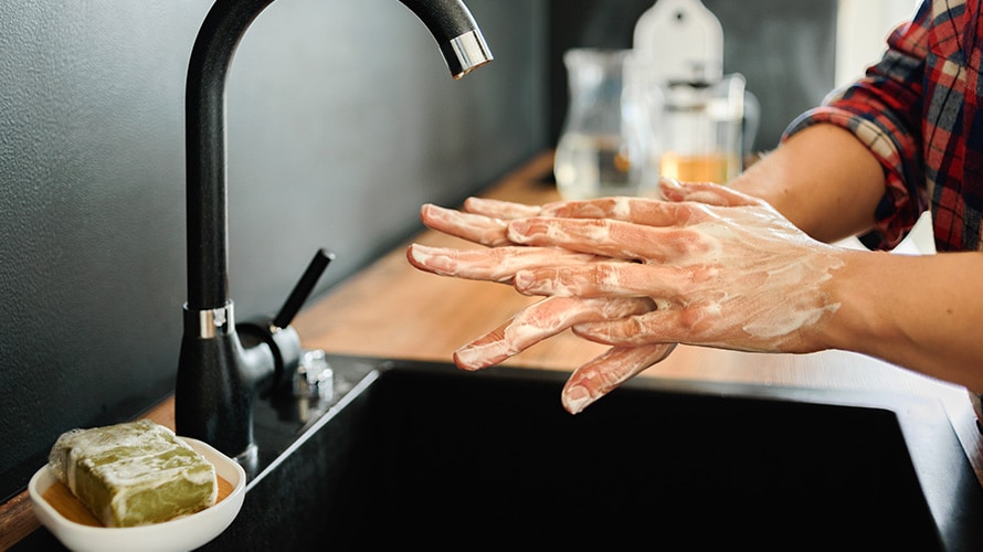 Person washing their hands with soap and water.