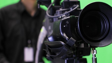 Close-up of a Television camera and camera man filming a Television scene