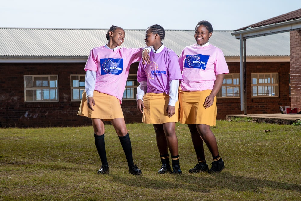 three girls in soccer uniforms