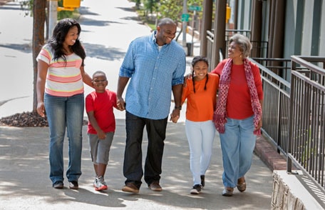 family of persons of color on a sidewalk