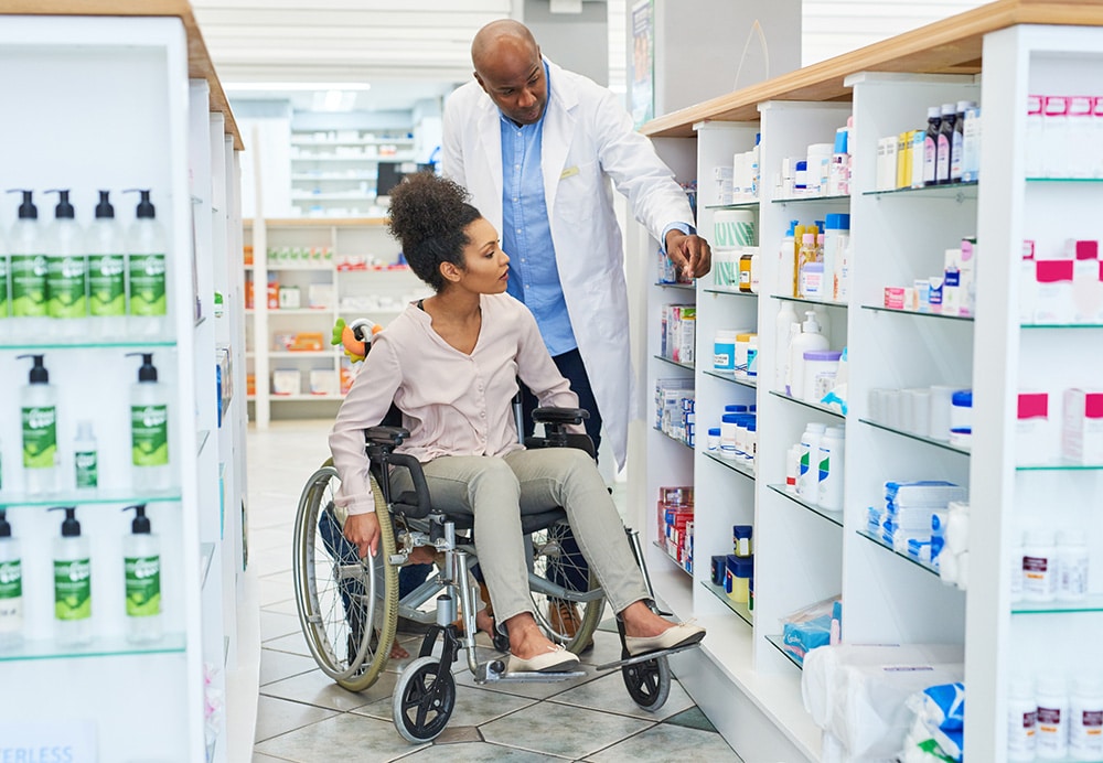 woman in wheelchair being assisted by pharmacy worker