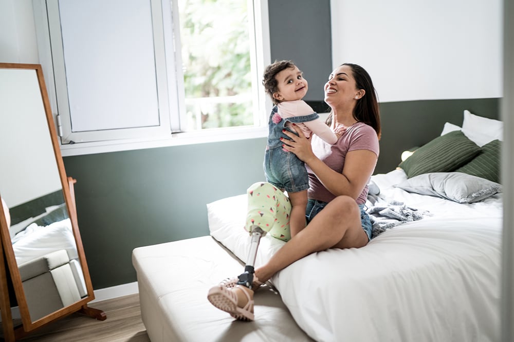 woman sitting on bed playing with child