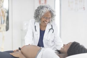 Physician examining pregnant woman.