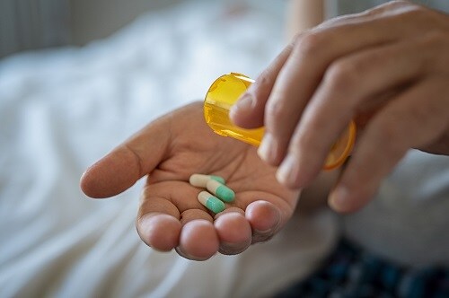 Three medicine capsules in a person's hand