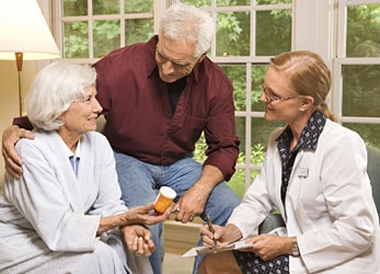 Senior couple discussing medication with a care physician.