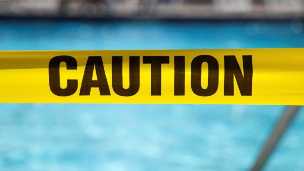 Caution tape in front of a pool.