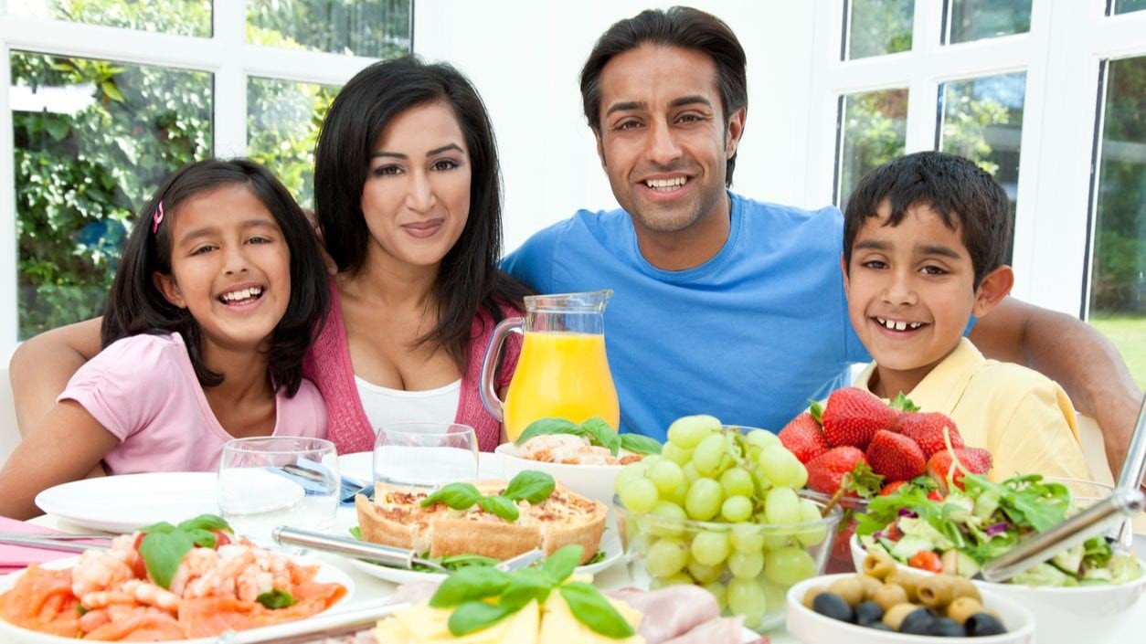 A family sitting around a table with plates of healthy food choices.