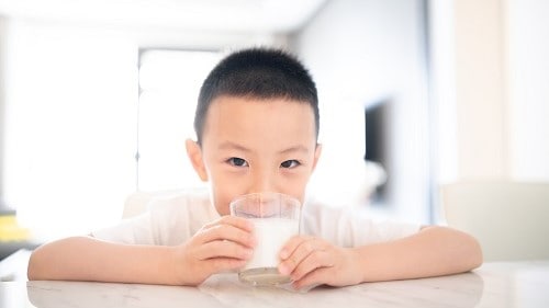 Boy drinking a glass of milk.