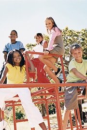six children sitting on a climbing frame